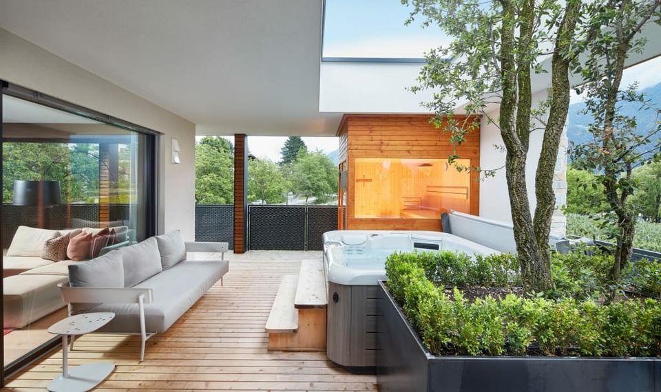 Chalet-Loggia mit Whirlpool und Sauna Eine Chalet-Loggia mit Whirlpool, Sauna und Sitzbereich unter freiem Himmel.