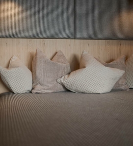 A relaxation area in the sauna with several cushions and a padded bench.