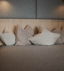 A relaxation area in the sauna with several cushions and a padded bench.