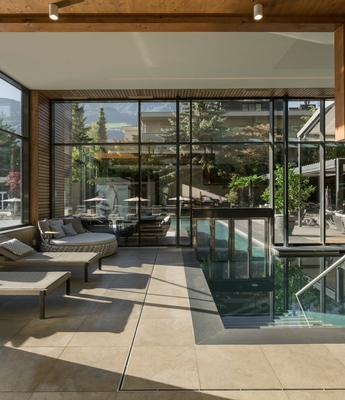 Ruheraum im Wellnesshotel in Naturns Ein heller Ruheraum mit Liegen und Glasfront neben dem Innenpool im Wellnessbereich.
