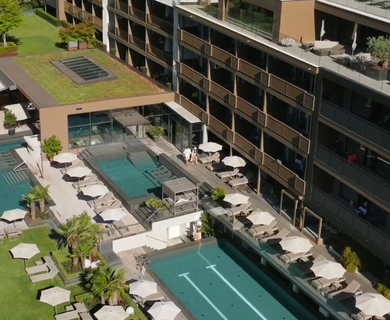 Hotelpool und Dachgarten im Feldhof Resort Blick auf den Hotelpool, Liegen und einen begrünten Dachgarten am Feldhof DolceVita Resort.