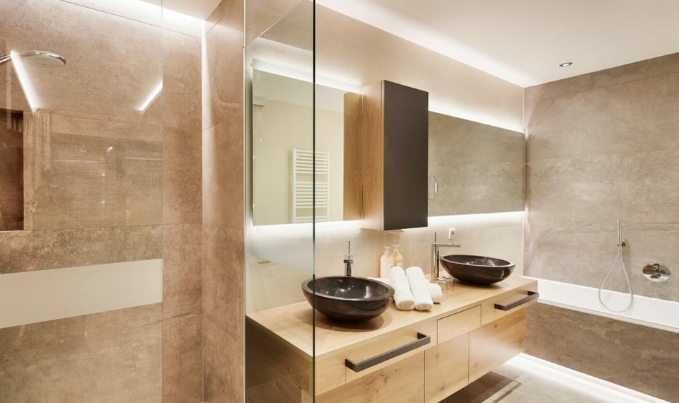 Badezimmer im Chalet mit Doppelwaschbecken Modernes Badezimmer im Chalet mit zwei Aufsatzwaschbecken, großer Spiegelwand und offener Dusche.