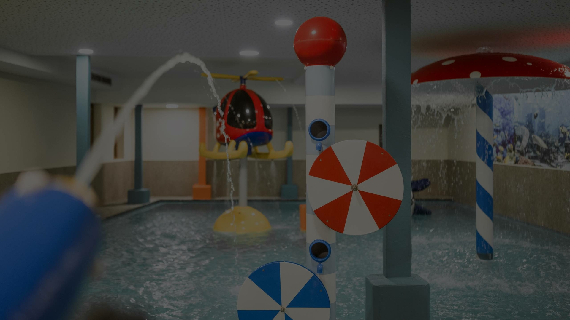Ein Kinderbereich mit flachem Pool, Wasserspielen und bunten Rutschen im Family Spa.