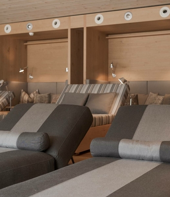 Ruhebereich mit Liegen im Wellnesshotel Gemütlicher Ruhebereich mit gepolsterten Liegen, Kissen und warmen Holzelementen.