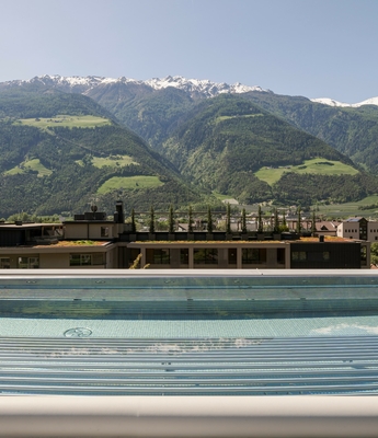 Pool auf der Dachterrasse mit Bergblick Ein Pool auf der Dachterrasse mit Blick auf die grünen Berge und den Himmel im Hintergrund.