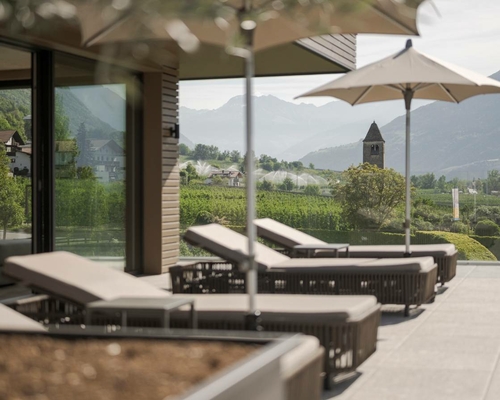Loungers and parasols stand on the panoramic terrace of the Adults Only Sky Spa overlooking the valley.