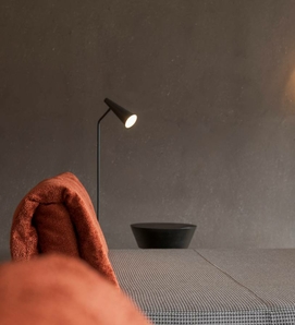 A lounger with a brown towel stands in the softly lit relaxation room of the sauna area.