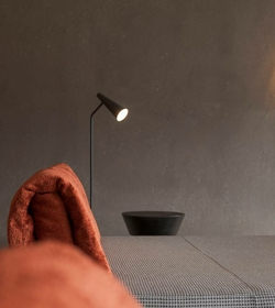 A lounger with a brown towel stands in the softly lit relaxation room of the sauna area.