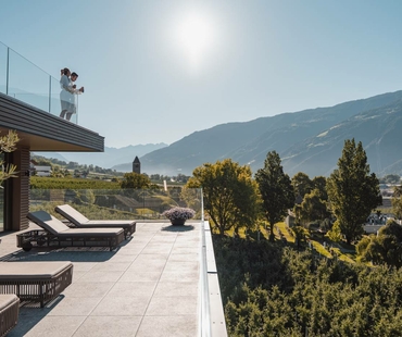 A panoramic terrace with loungers overlooking the mountains and valley.