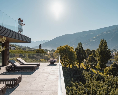 A panoramic terrace with loungers overlooking the mountains and valley.