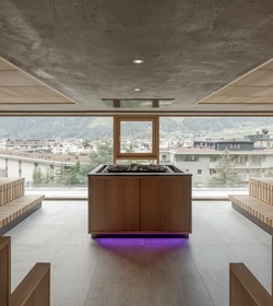 Ein Ruheraum im Sky Spa mit Liegen, Fensterfront und Blick auf den Ort.