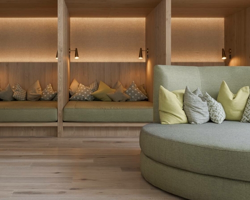 A cozy relaxation area with wooden loungers and a padded seating nook.
