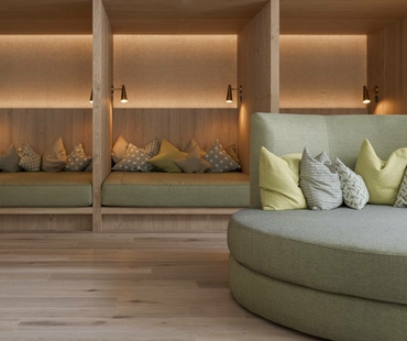 A cozy relaxation area with wooden loungers and a padded seating nook.
