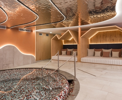 Ruhebereich mit Whirlpool im Feldhof DolceVita Resort Ein ruhiger Wellnessbereich mit rundem Whirlpool, Liegenischen und warm beleuchteter Decke.