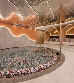Ein rundes Kinderbecken im Family Spa mit Liegen und sanfter Beleuchtung.