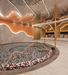 Ein rundes Kinderbecken im Family Spa mit Liegen und sanfter Beleuchtung.