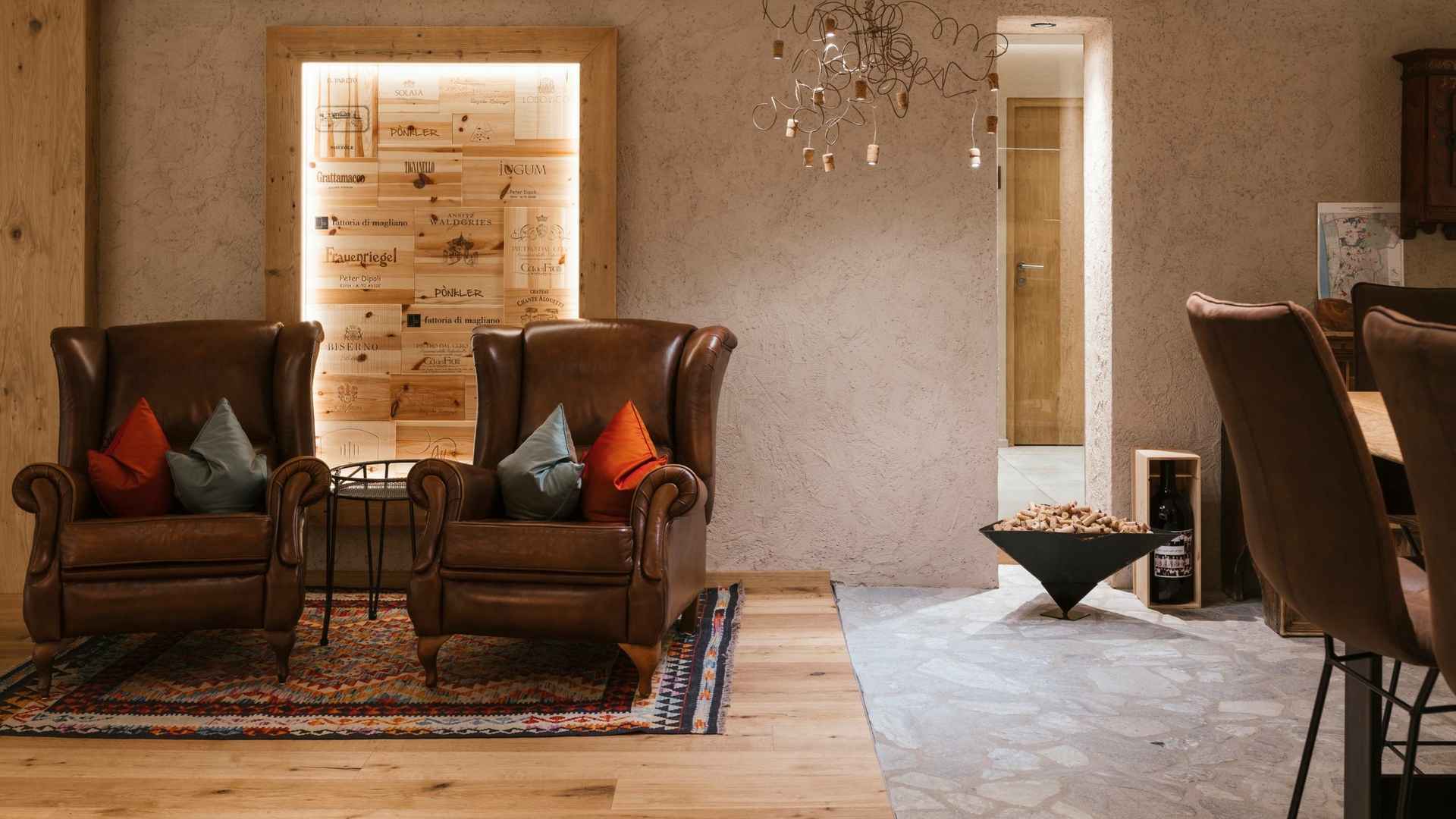 Zwei Ledersessel stehen in einer stilvollen Lounge mit Teppich, Holzboden und dezenter Beleuchtung.