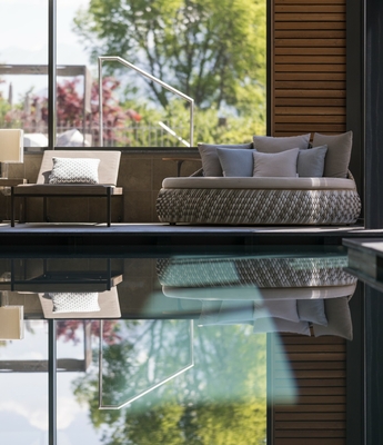 Relaxbereich am Innenpool im Wellnesshotel Feldhof Ein ruhiger Liegebereich mit Sitzmöbeln liegt direkt am Innenpool mit Spiegelung.