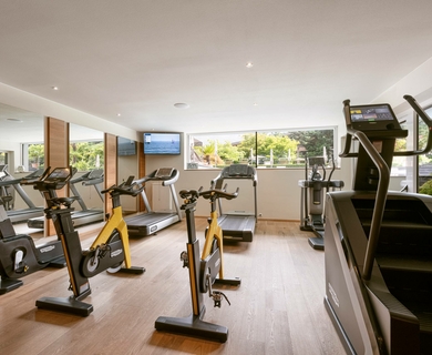 Fitnessraum im Feldhof DolceVita Resort Ein heller Fitnessraum mit Laufbändern, Hometrainern und einem Crosstrainer im Feldhof DolceVita Resort.
