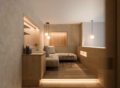 A modern suite with a sofa, wooden furnishings and soft ambient lighting at Feldhof in Naturns.