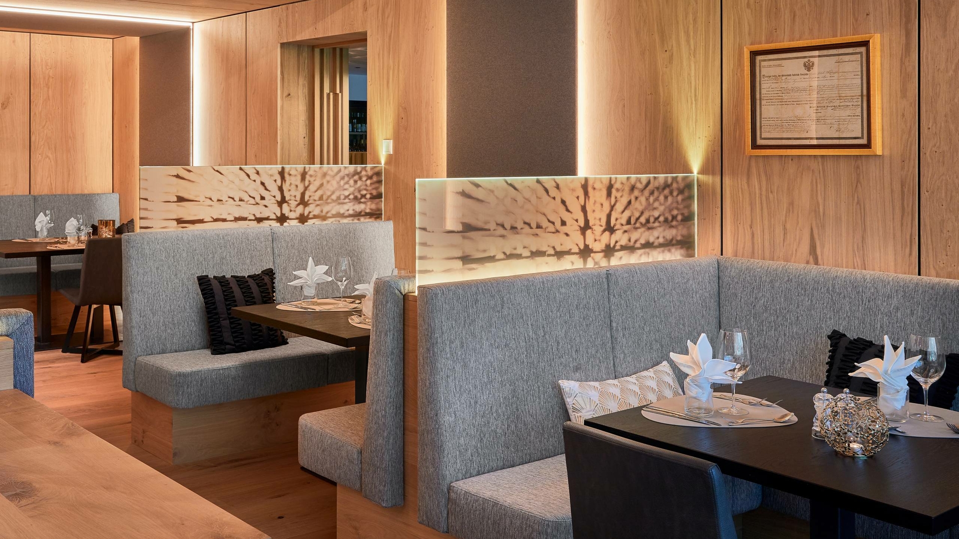 Gemütliche Sitznischen und gedeckte Tische im Restaurant des Feldhof DolceVita Resort.