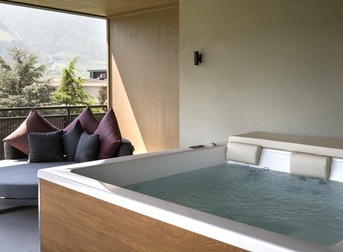 Suite con whirlpool e vista montagna a Naturno Una suite con whirlpool privato e zona lounge si apre su un balcone con vista sulle montagne.