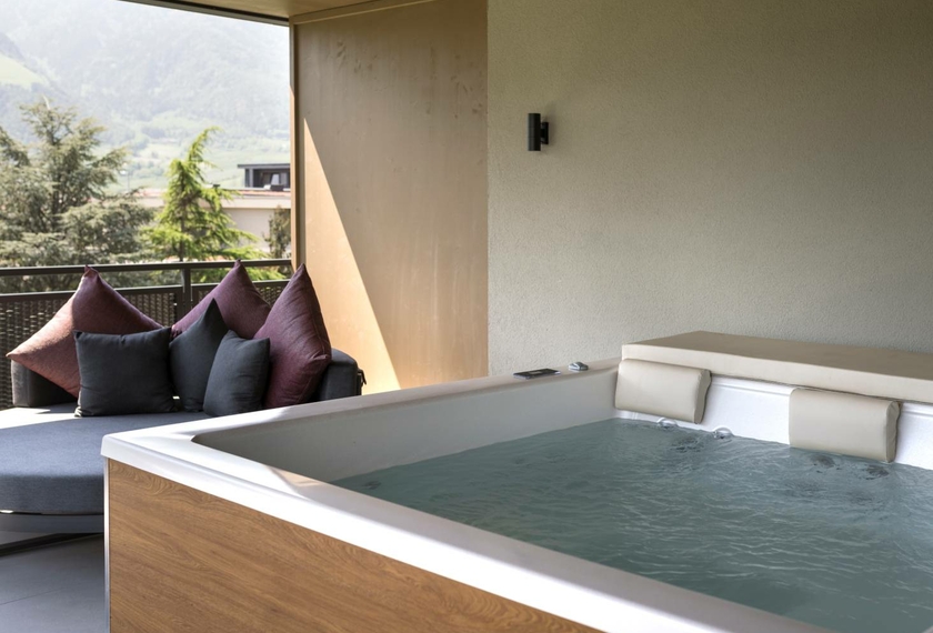 Suite con whirlpool e vista montagna a Naturno Una suite con whirlpool privato e zona lounge si apre su un balcone con vista sulle montagne.