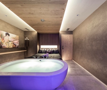A private spa room with a whirlpool, loungers and soft ambient lighting.