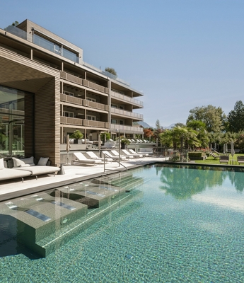 Pool im Wellnesshotel in Naturns Der Außenpool mit Lounge-Bereich liegt neben dem modernen Wellnesshotel und den Liegewiesen.