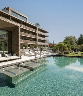 Pool im Wellnesshotel in Naturns Der Außenpool mit Lounge-Bereich liegt neben dem modernen Wellnesshotel und den Liegewiesen.