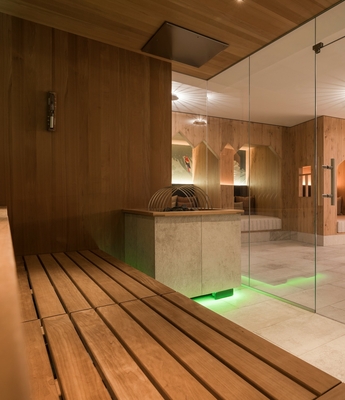 Sauna im Wellnesshotel in Naturns Holzsauna mit Glasfront und Blick in den Ruhebereich des Wellnesshotels.