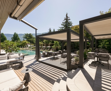 Poolterrasse im Feldhof DolceVita Resort Eine Poolterrasse mit Liegen, Sitzgruppen und überdachten Lounge-Bereichen im Feldhof DolceVita Resort.