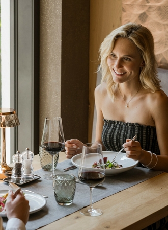Ein Paar sitzt im Hotelrestaurant und genießt ein elegantes Dinner am Tisch am Fenster.