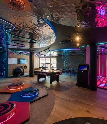 Family Spa mit Kinderbereich im Feldhof Ein bunter Indoor-Bereich mit Spiel- und Bewegungsflächen, leuchtendem Boden und moderner Decke.