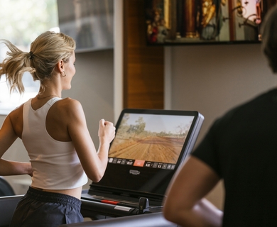 Fitnessbereich im Feldhof DolceVita Resort Eine Frau trainiert auf einem Laufband im Fitnessbereich des Resorts.