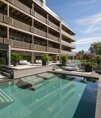 Sky Pool am Wellnesshotel in Naturns Der Außenpool liegt direkt vor dem modernen Wellnesshotel mit Terrassen und Liegebereichen.