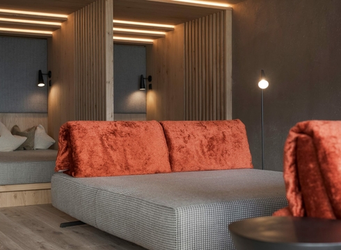 Ruhebereich im Wellnesshotel in Naturns Ein moderner Ruhebereich mit Liegen, warmen Holzdetails und gedämpfter Beleuchtung.
