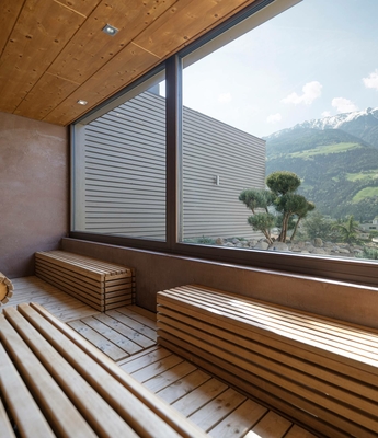 Sauna mit Bergblick im Wellnesshotel Naturns Holzsauna mit großen Panoramafenstern und Blick auf die Berge.