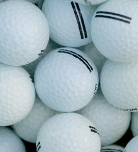 Several white golf balls are piled closely together and fill the entire frame.